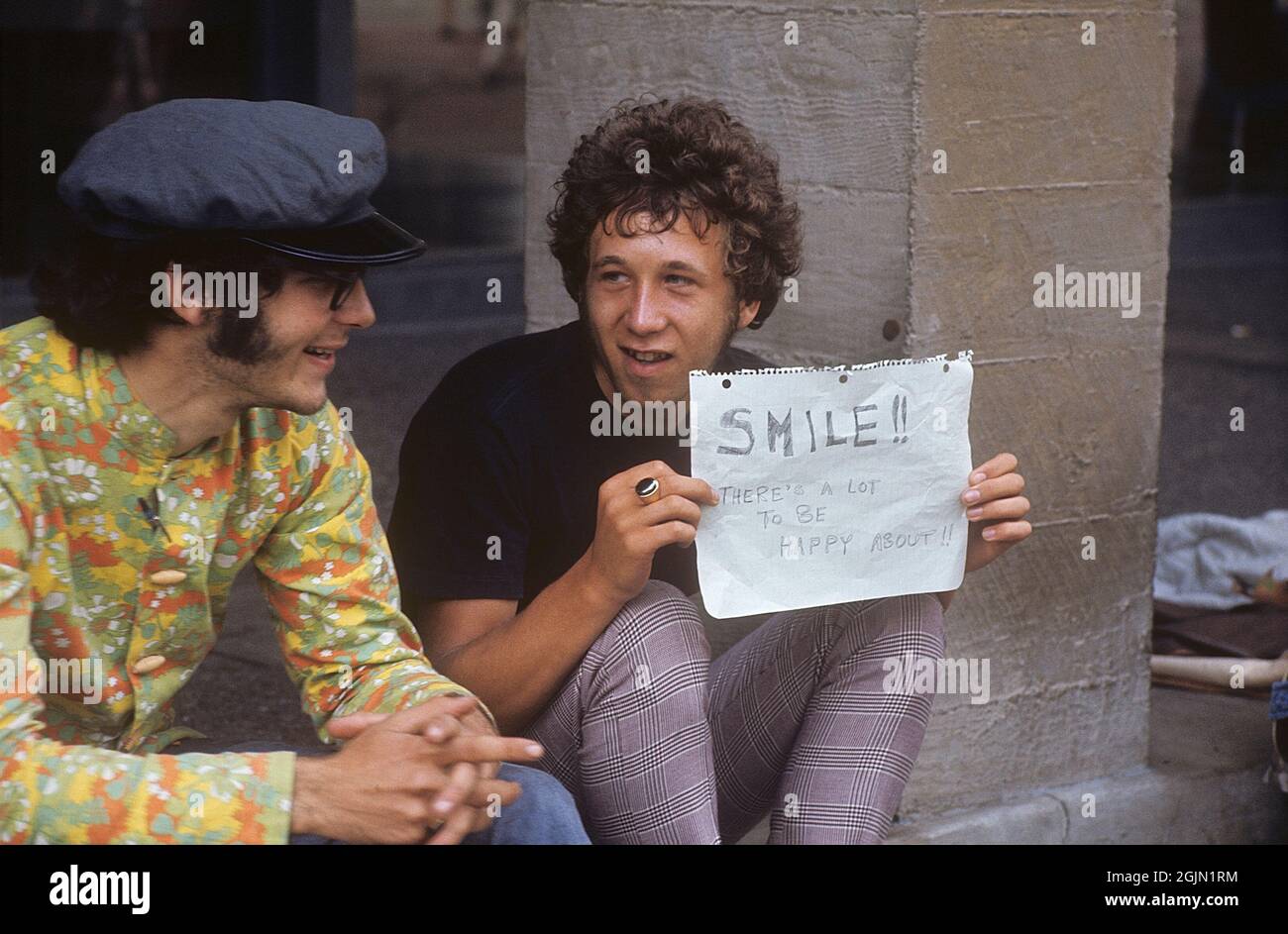 USA december 1968. Students at University of California Berkeley in typical 1968 clothes. The young man is holding an handwritten sign with the message: Smile!! There's a lot to be happy about!! 6-1-19 Credit Roland Palm ref 6-1-13 Stock Photo