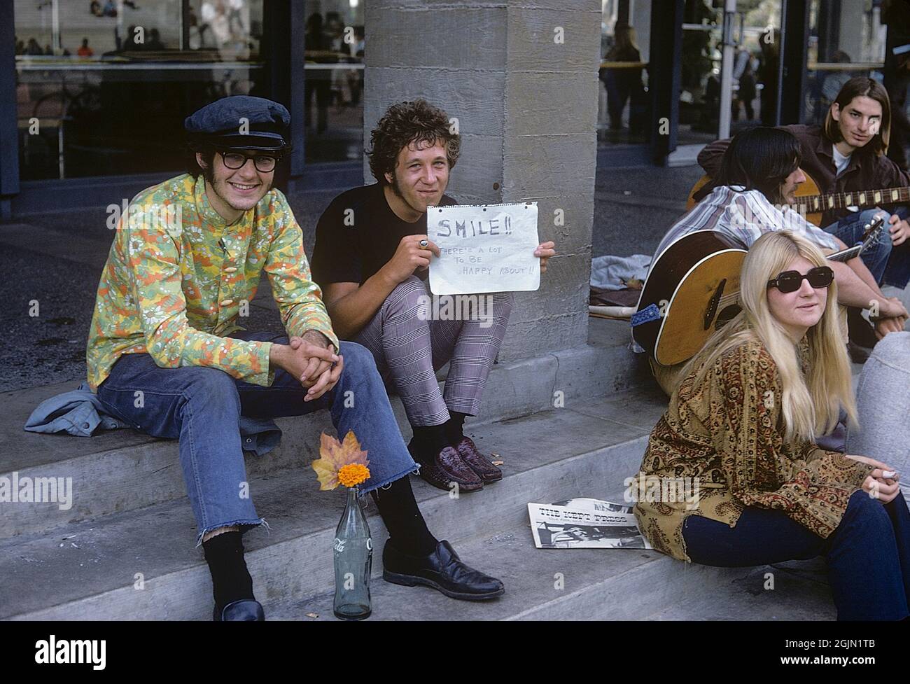 USA december 1968. Students at University of California Berkeley in typical 1968 clothes. The young man is holding an handwritten sign with the message: Smile!! There's a lot to be happy about!! 6-1-19 Credit Roland Palm ref 6-1-15 Stock Photo