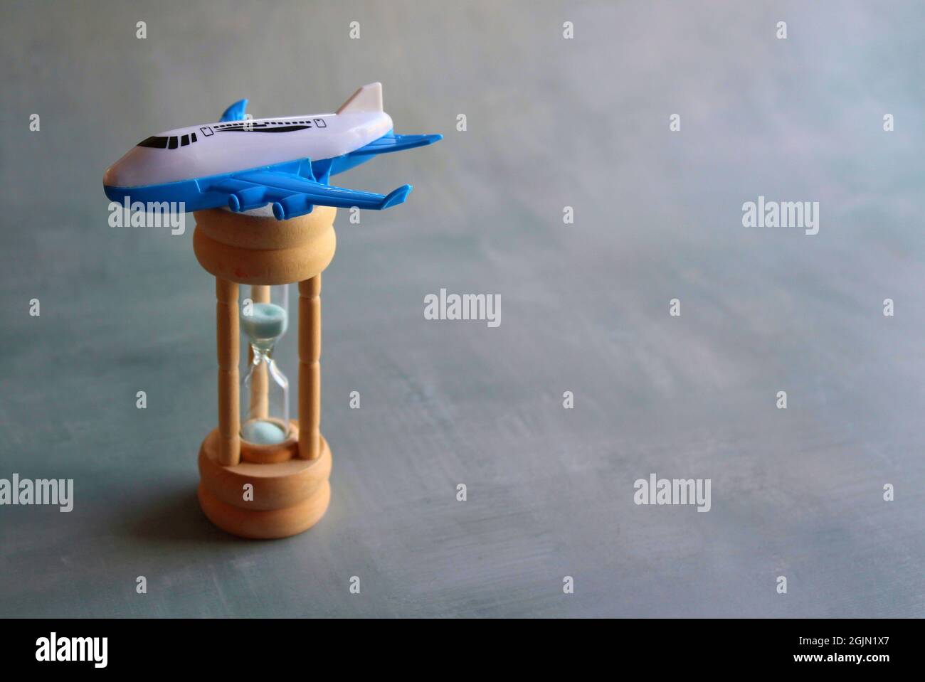 Expected time of arrival, flight delay and arrival concept. Selective focus image of plane on hourglass with copy space for text Stock Photo