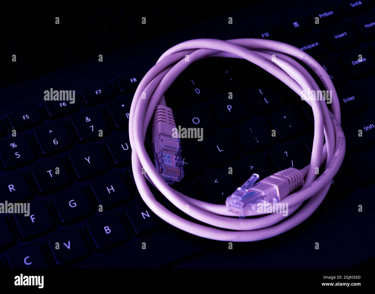 Network Cable resting on a computer keyboard Stock Photo