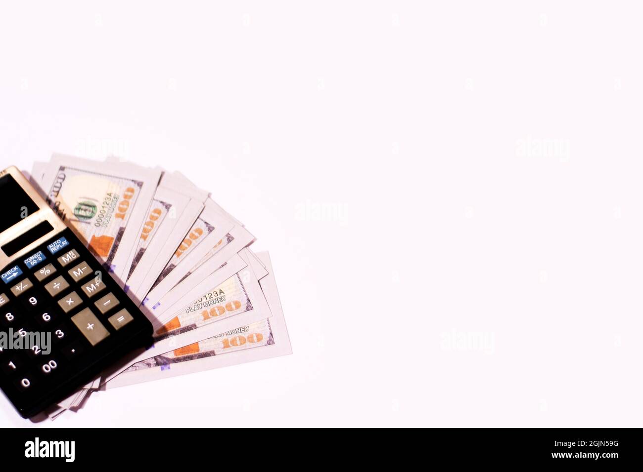 Counting US paper currency one hundred dollar in a calculator on isolated white background. Stock Photo