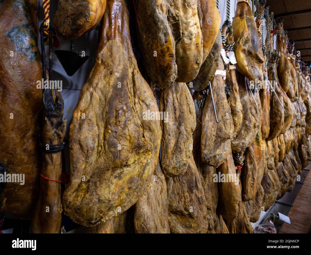 Dried pork thighs hang on the meat market. Spanish national dish of ham or jamon in a grocery
