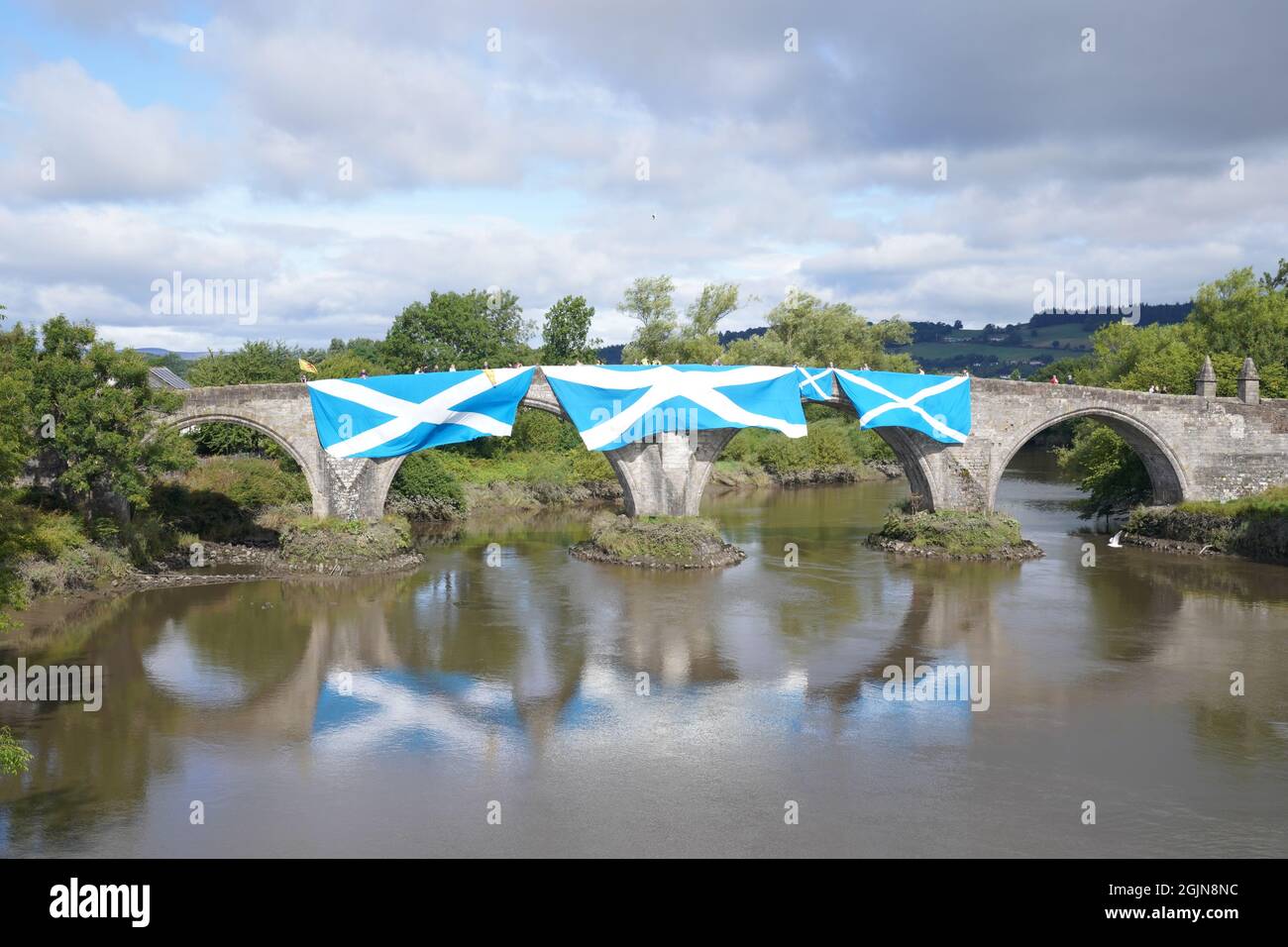 Supporters of Scottish independence hang saltire flags over the Auld Brig, at the site of the Battle of Bannockburn, for an 'All Under One Banner' rally in Bannockburn, Stirling. The site of the Battle of Bannockburn, is where the army of the King of Scots Robert the Bruce defeated the army of England's King Edward II in 1314, during the first war of Scottish Independence. Picture date: Saturday September 11, 2021. Stock Photo