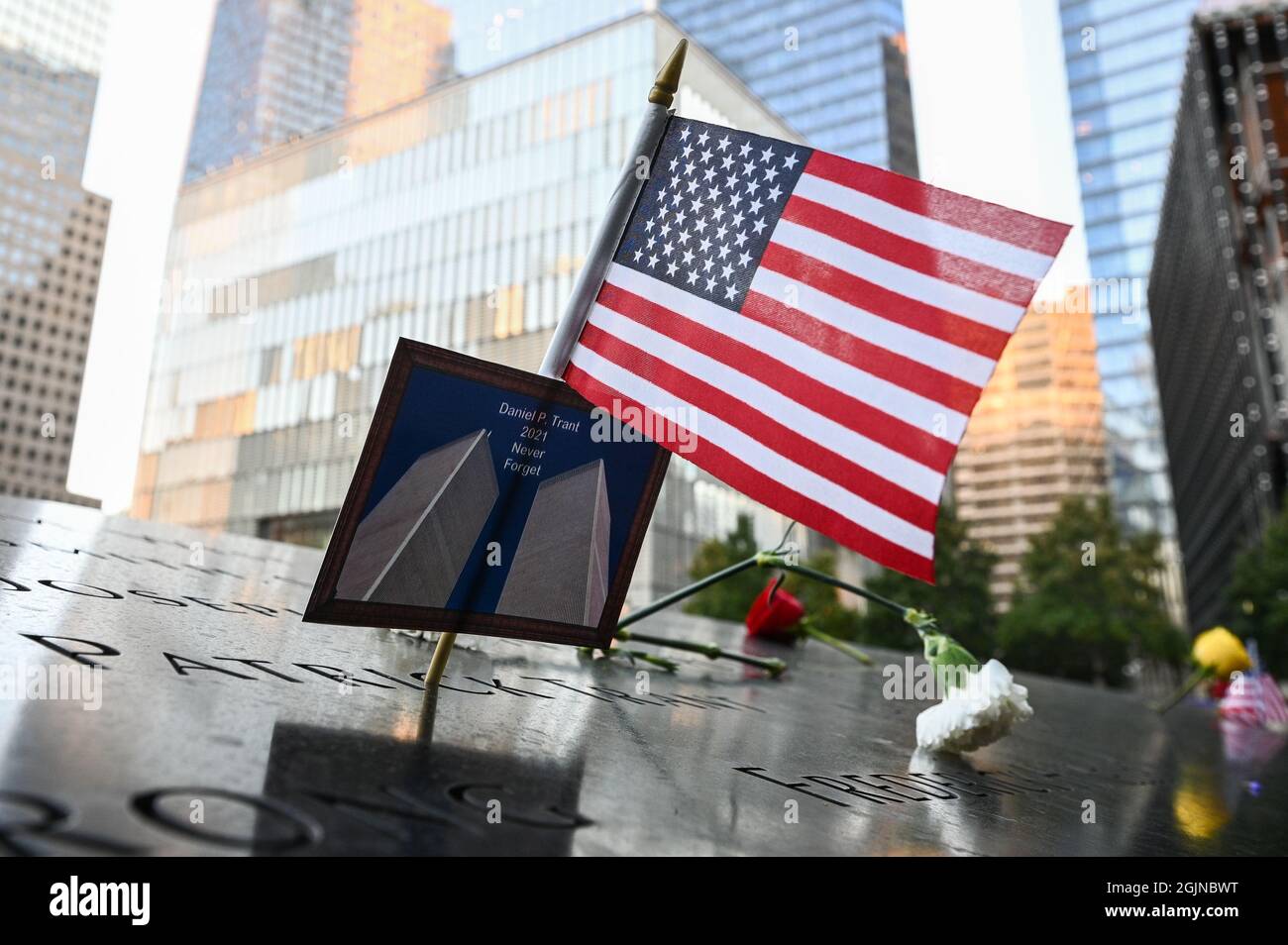 New York, USA. 11th Sep, 2021. An American flag placed along with a photo of the Twin Towers and the name Daniel P. Trant, a Cantor Fitzgerald bond trader that died during 9/11, at a ceremony at Ground Zero held in commemoration of the 20th anniversary of the terrorist attacks on the World Trade Center, the Pentagon and the crash of United Airlines Flight 93 in Shanksville, PA, held in lower Manhattan, New York City, NY, on Sept. 11, 2021. Pool photo by Anthony Behar/UPI Credit: UPI/Alamy Live News Stock Photo