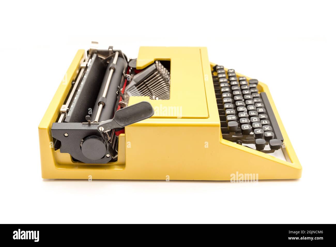 Studio photo of a vintage mustard yellow typewriter on a white background Stock Photo