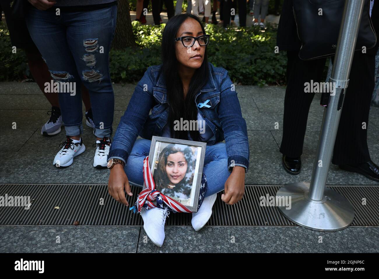 New York, USA. 11th Sep, 2021. NEW YORK, NEW YORK - SEPTEMBER 11: A family member of Jennie Nicole Gonzalez attends the annual 9/11 Commemoration Ceremony at the National 9/11 Memorial and Museum on September 11, 2021 in New York City. During the ceremony six moments of silence were held, marking when each of the World Trade Center towers was struck and fell and the times corresponding to the attack on the Pentagon and the crash of Flight 93. The nation is marking the 20th anniversary of the terror attacks of September 11, 2001, when the terrorist group al-Qaeda flew hijacked airplanes into th Stock Photo