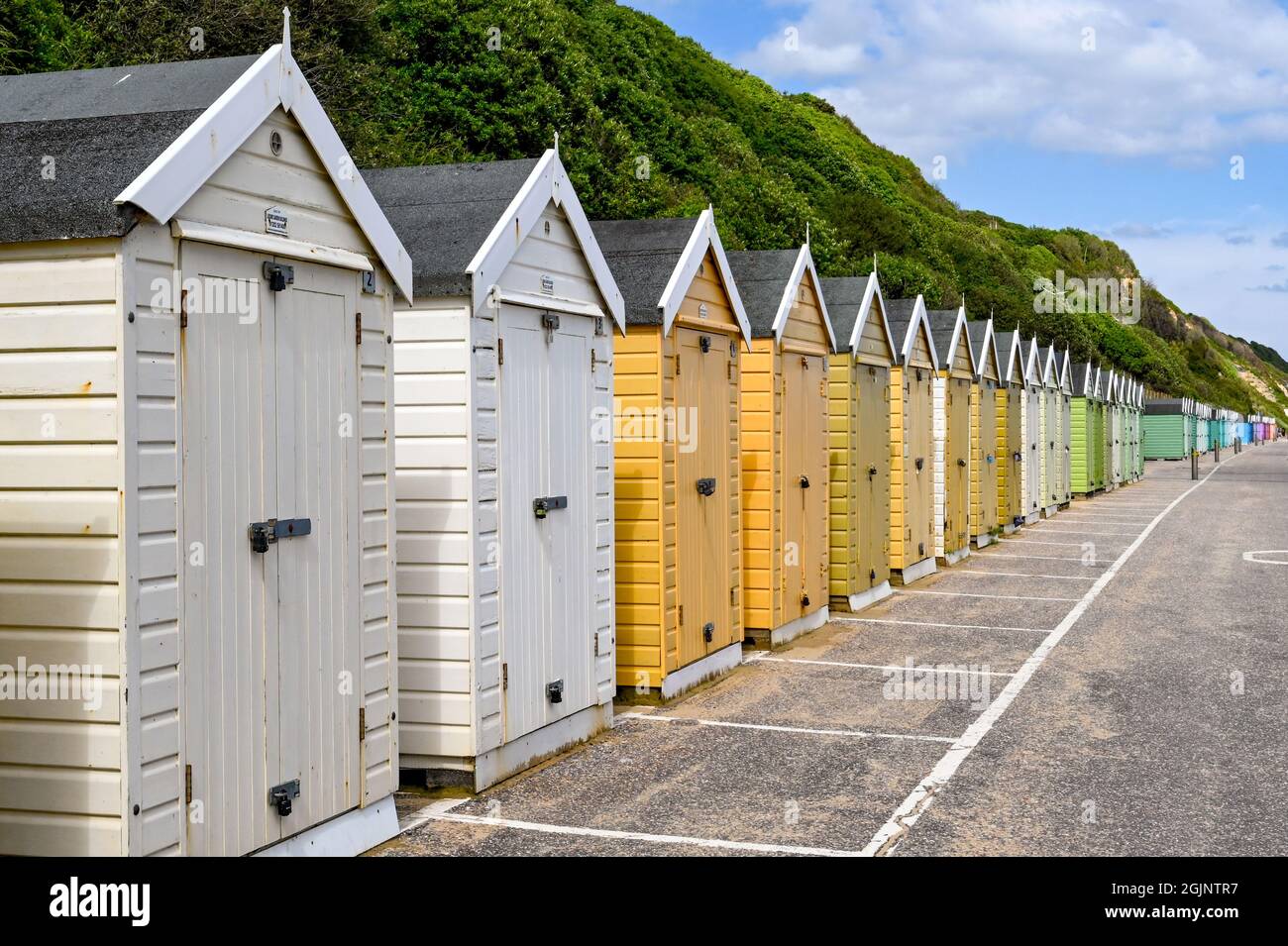 Bournemouth, Dorset, England - June 2021: Long row of beach huts below the cliffs in Bournemouth Stock Photo