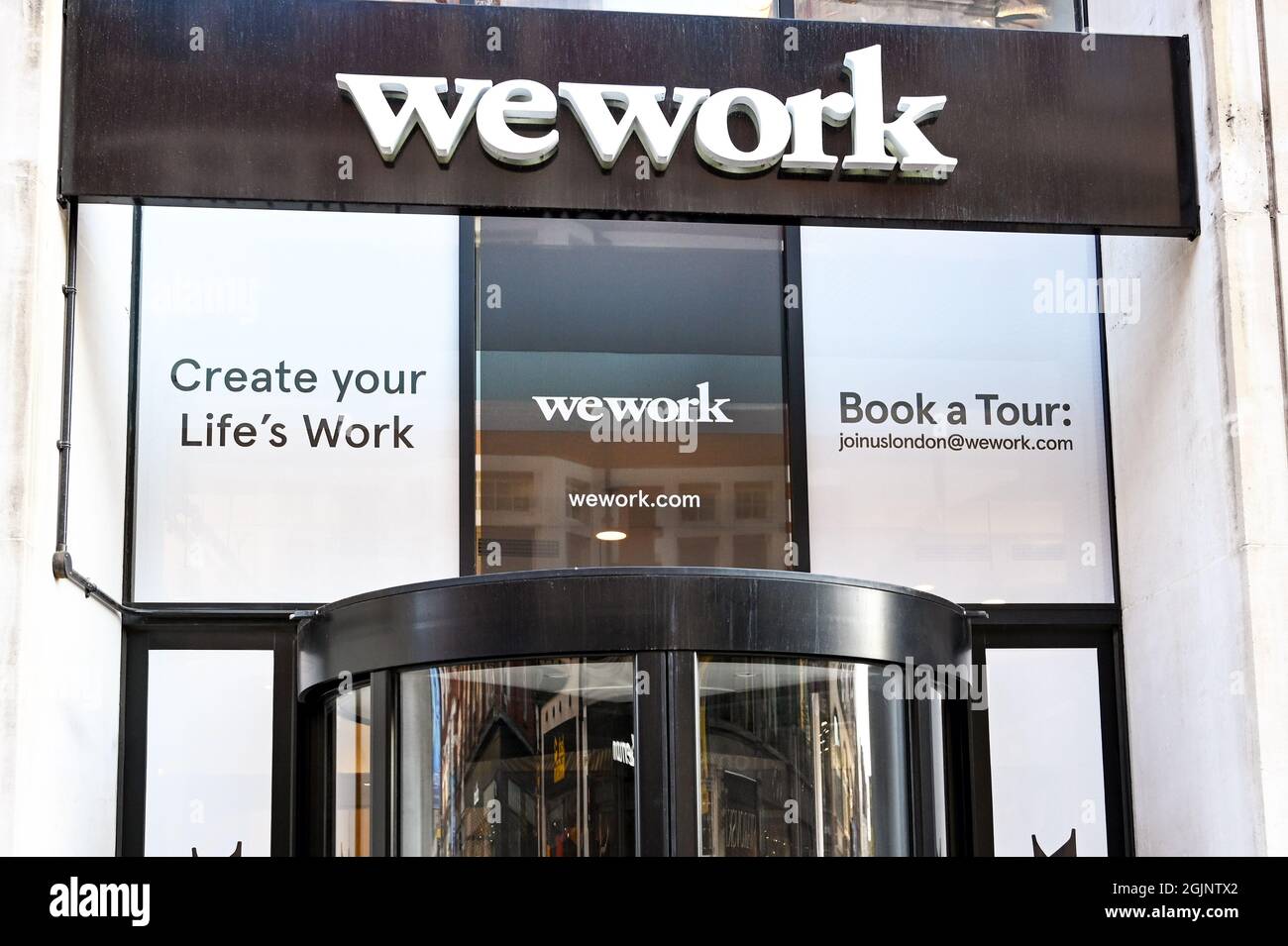 London, England - August 2021: Sign above the entrance to a branch of the We Work office space and co-working company Stock Photo
