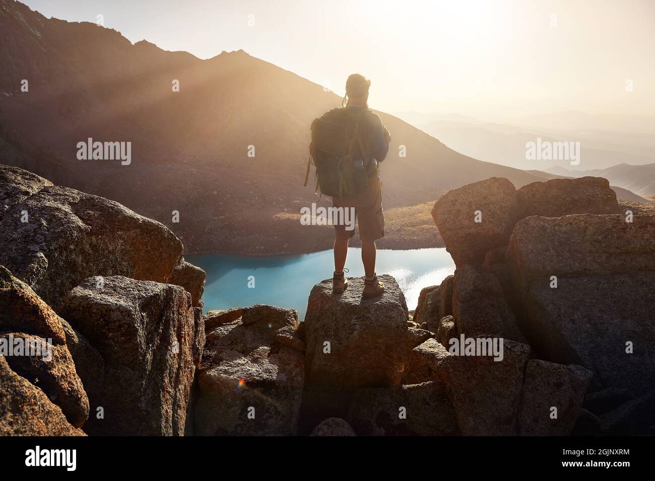 Silhouette of Man Hiker tourist man with backpack standing on the rock ...