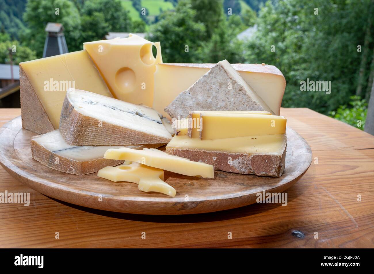 Cheese collection, wooden board with French cheeses comte, beaufort, abondance, emmental