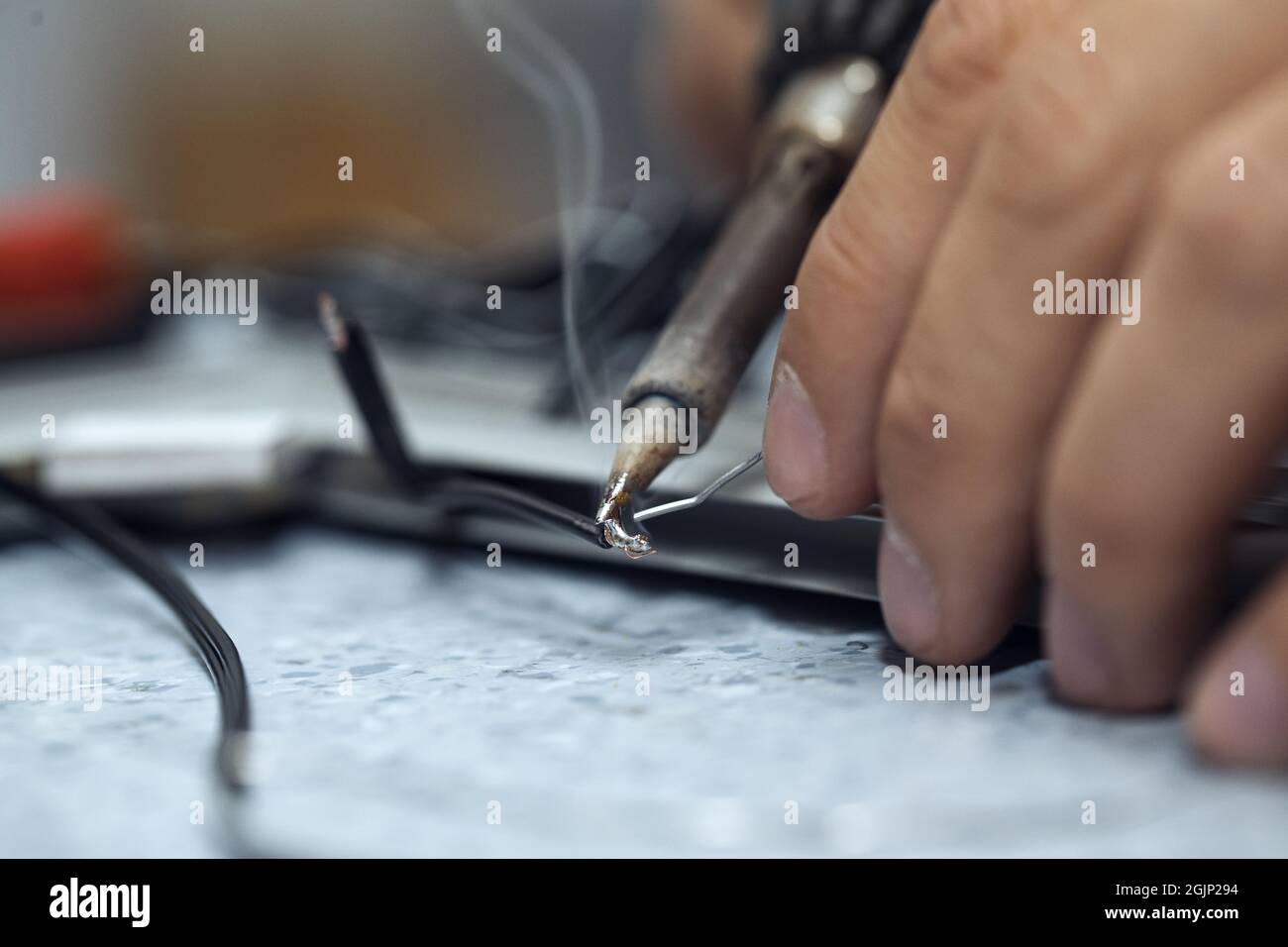 Wires being soldered together with a soldering iron. Melting solder