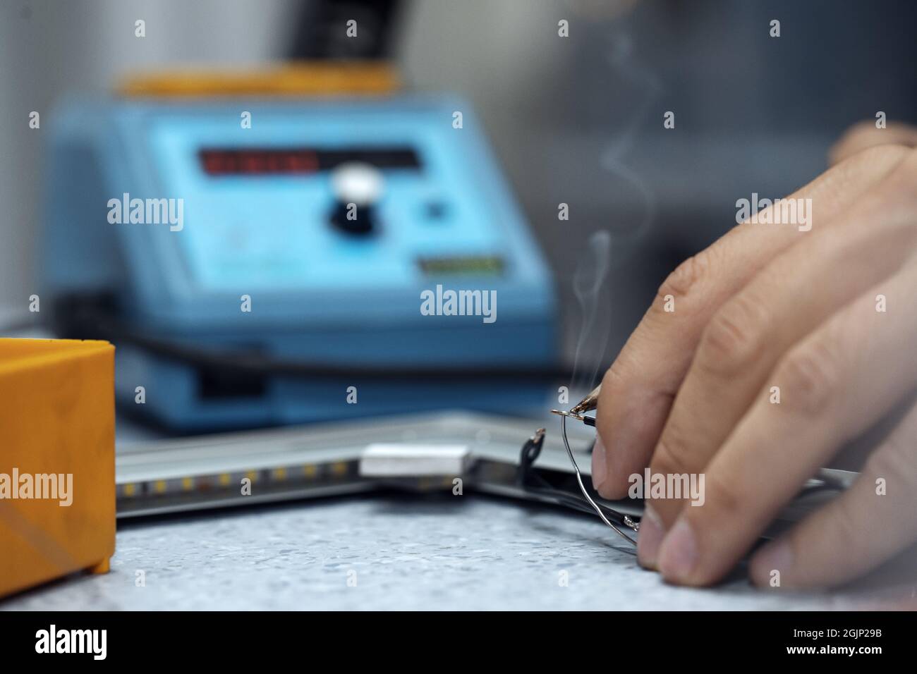 Wires being soldered together with a soldering iron. Melting solder