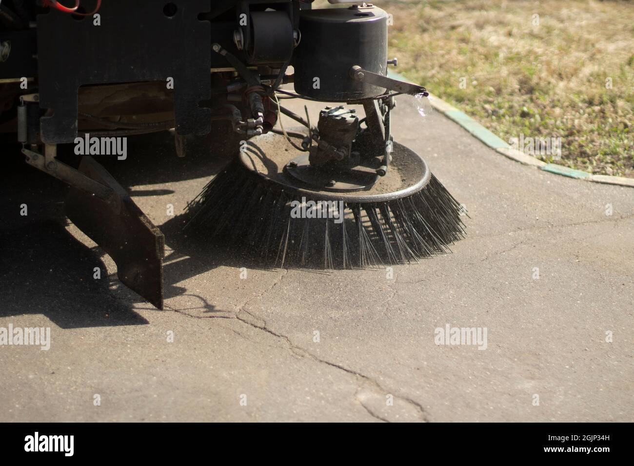 The sweeper is sweeping the asphalt. Cleaning the path with a cleaning