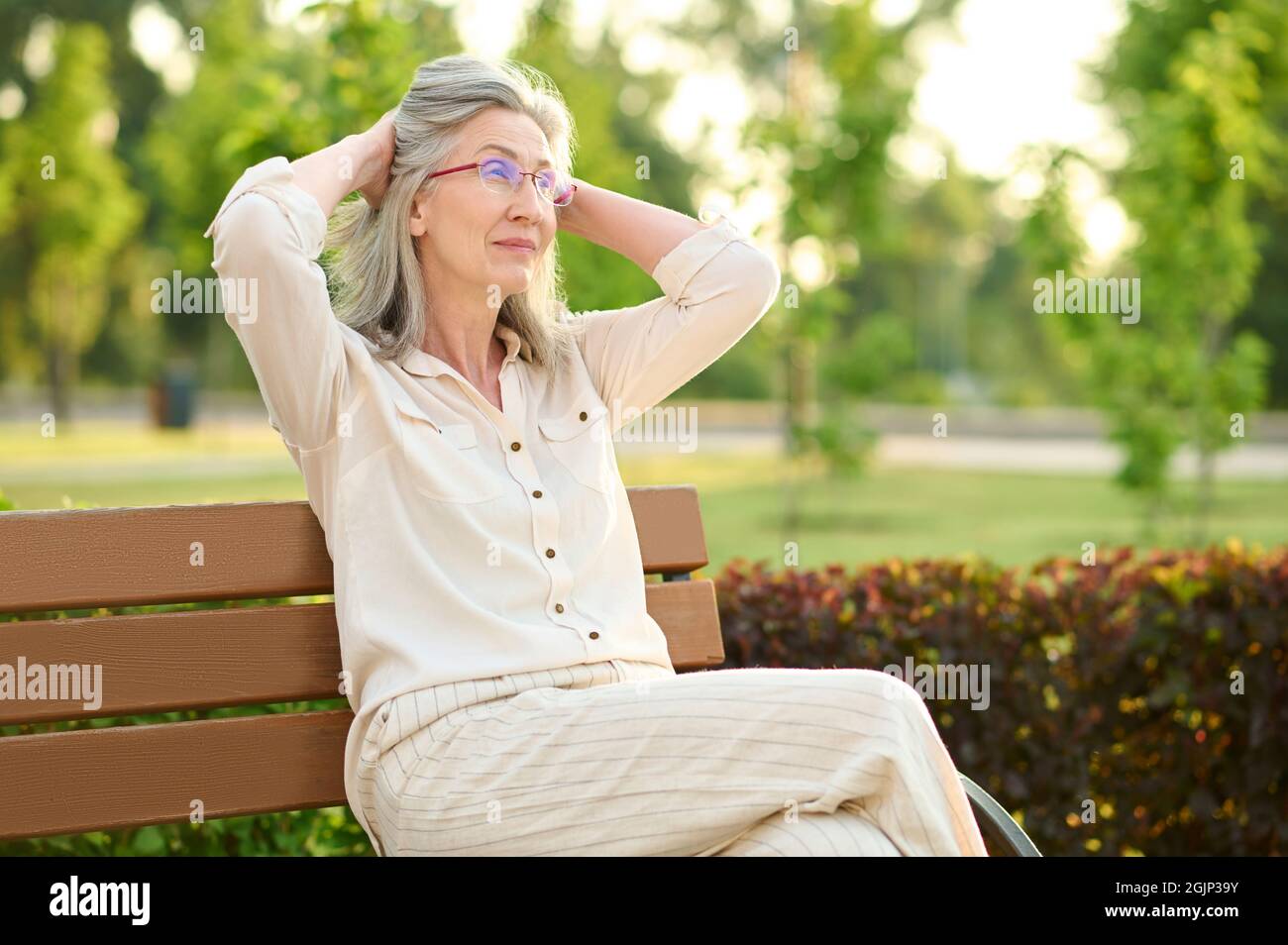 Calm woman resting on park bench Stock Photo