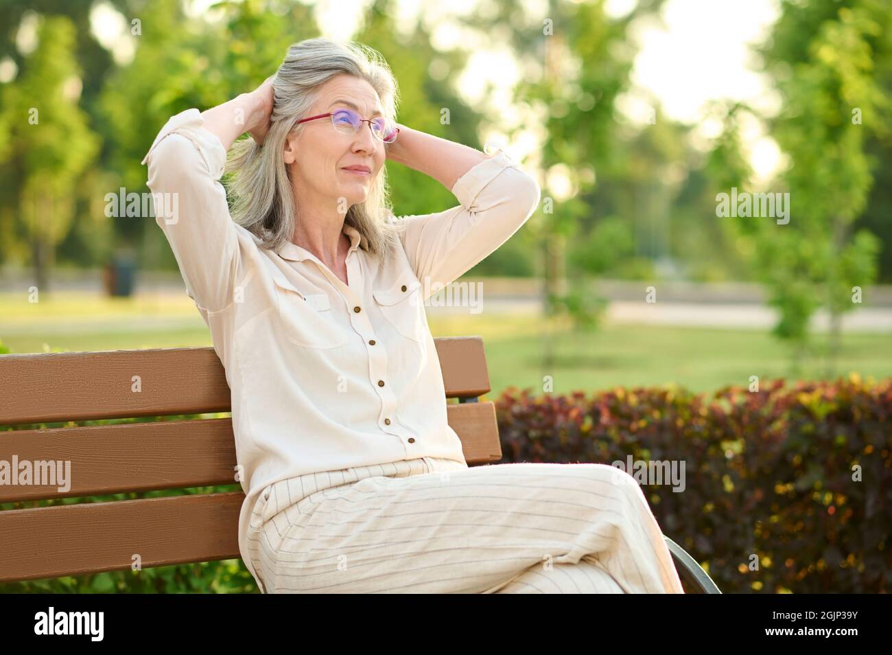 Calm woman resting on park bench Stock Photo - Alamy