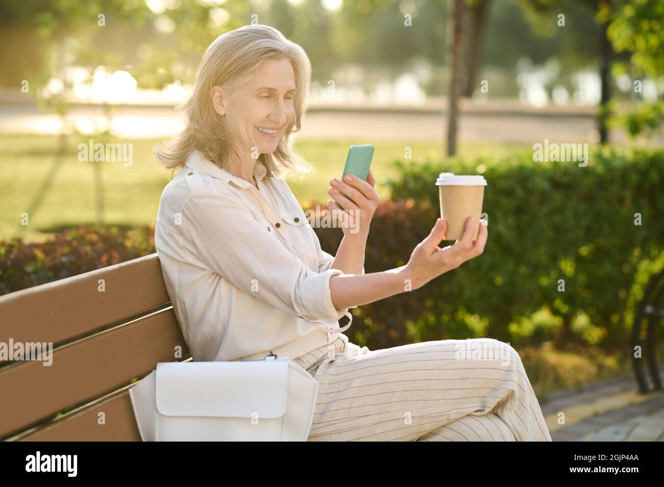 Woman with smartphone and glass of coffee Stock Photo