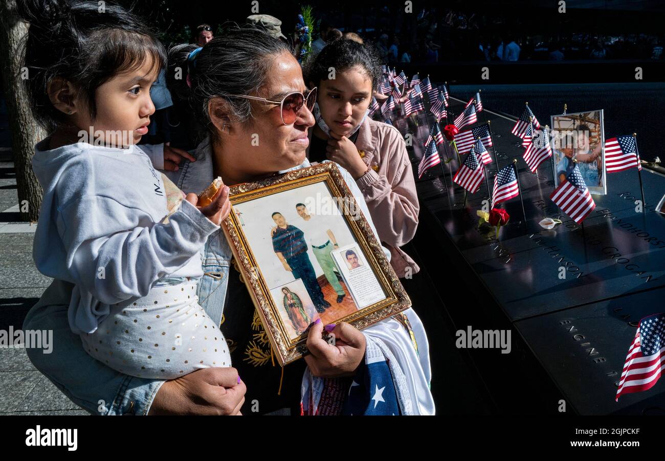 New York, USA. 11th Sep, 2021. Julia Melendez, holding the photo of her husband Antonio, who died working at Windows on the World restaurant during the attacks of Sept. 11, 2001, holds her granddaughter Scarlet, left, and Darlene as the attend the 20th Anniversary service at the 9/11 Memorial and Museum Saturday, Sept. 11, 2021, in New York. NYPPA Pool via Credit: Sipa USA/Alamy Live News Stock Photo