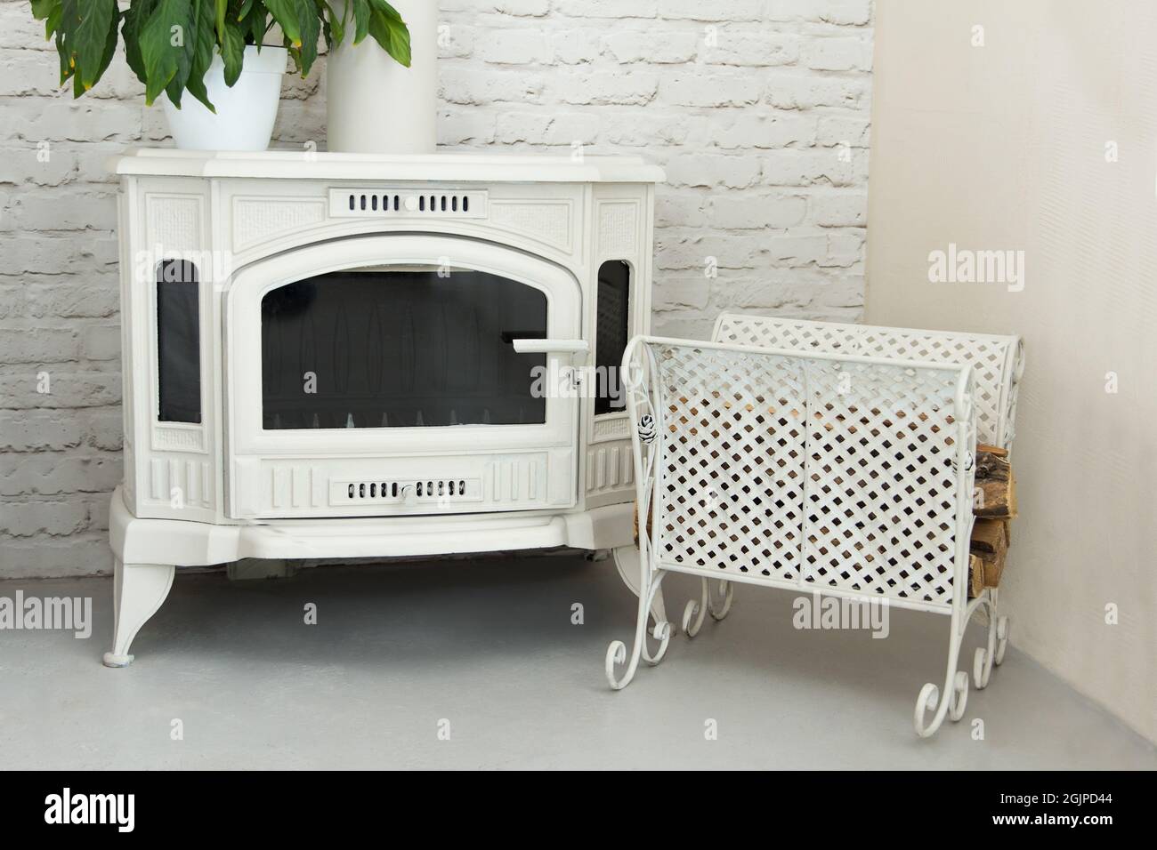 https://c8.alamy.com/comp/2GJPD44/new-beautiful-fireplace-on-wood-white-color-located-in-room-with-a-metal-wrought-pallet-2GJPD44.jpg