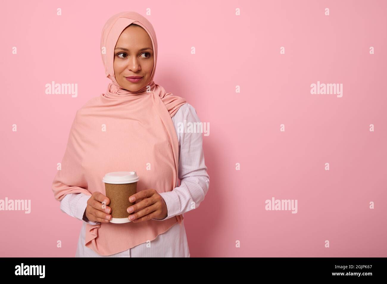 Arab Muslim beautiful woman wearing pink hijab and white shirt holding ...