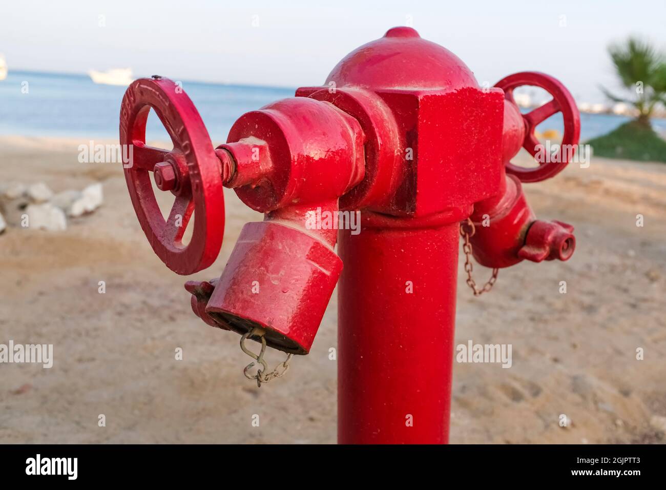 Close-up of a red fire hydrant in the desert. Sand and sea. Beach and palm trees Stock Photo