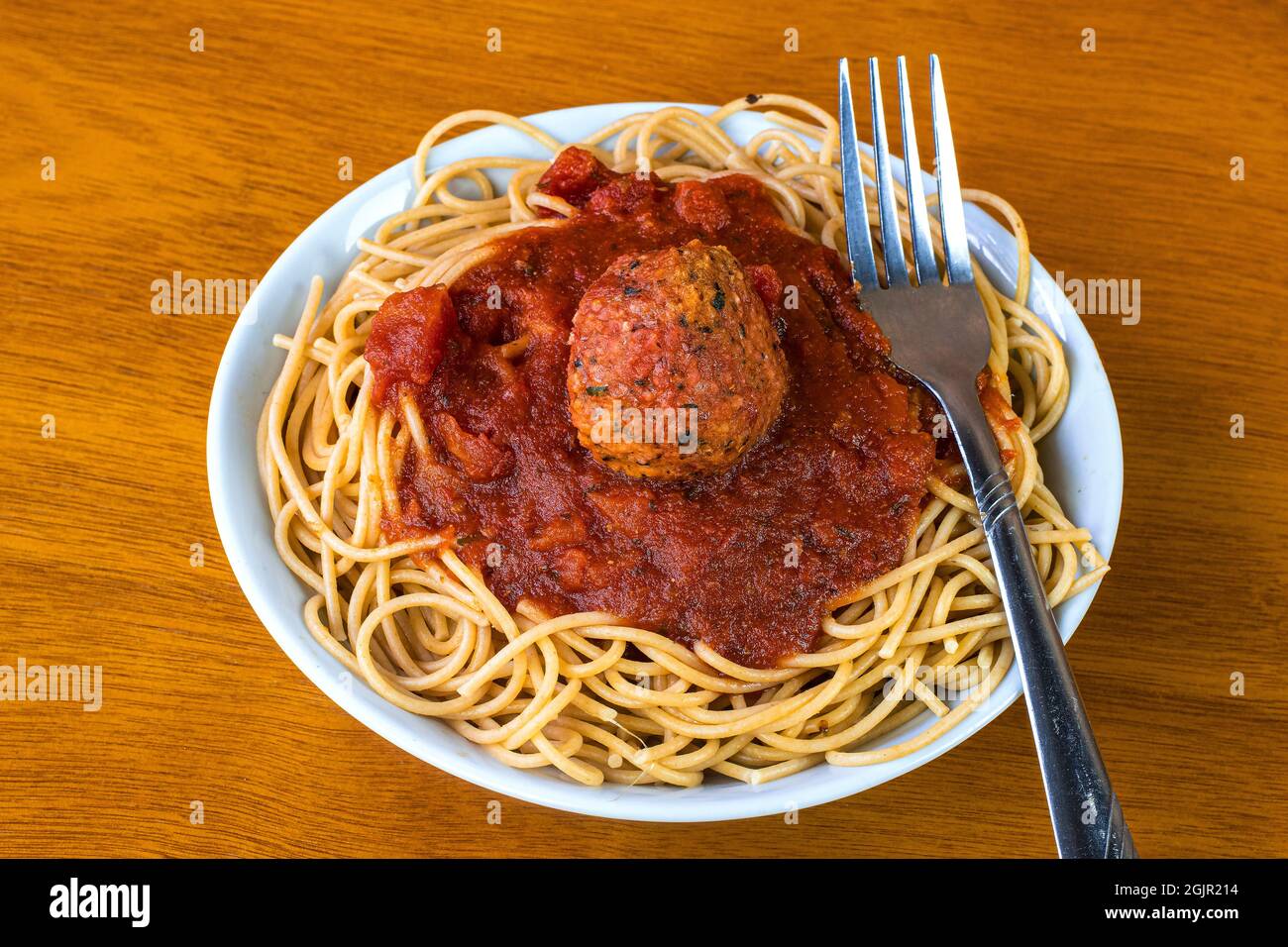 whole wheat spaghetti top with pasta sauce and plant based meat balls