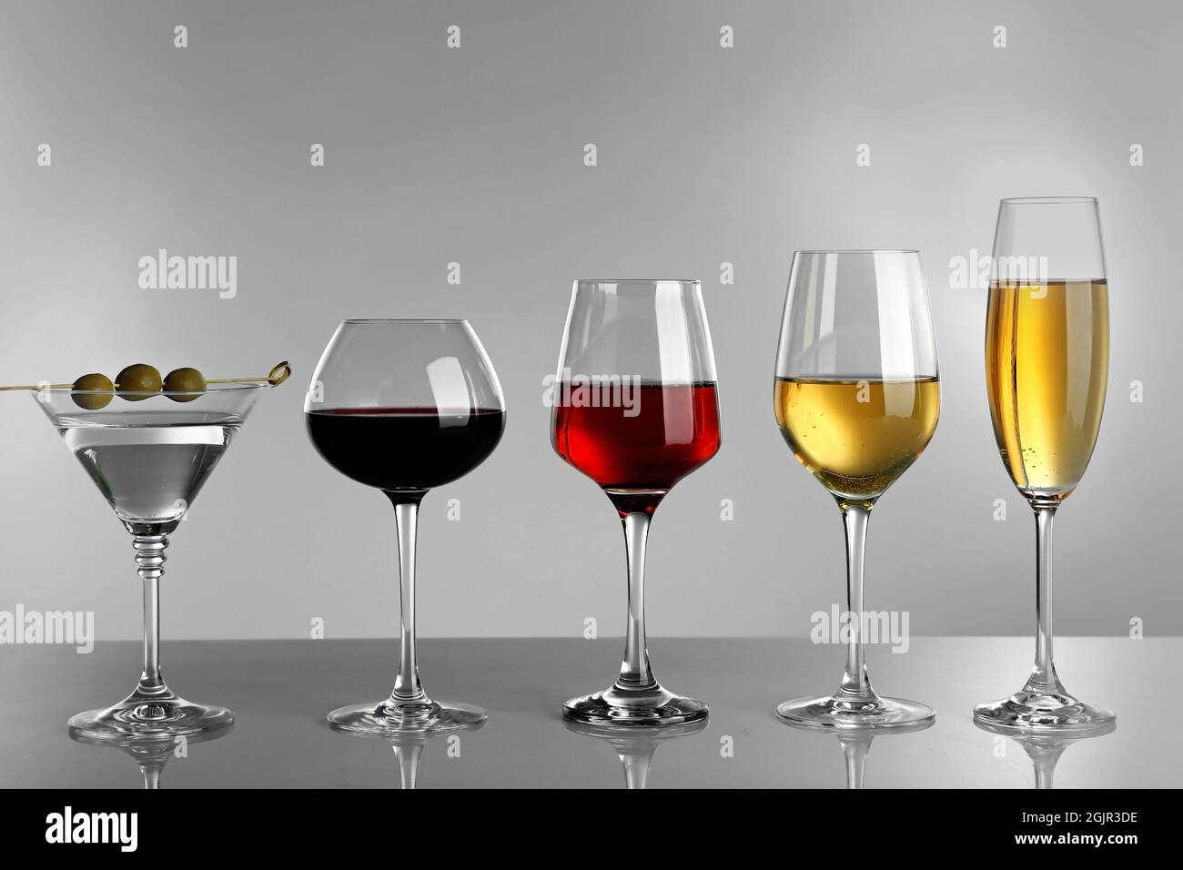 Glasses of wine and spirits on light background Stock Photo Alamy