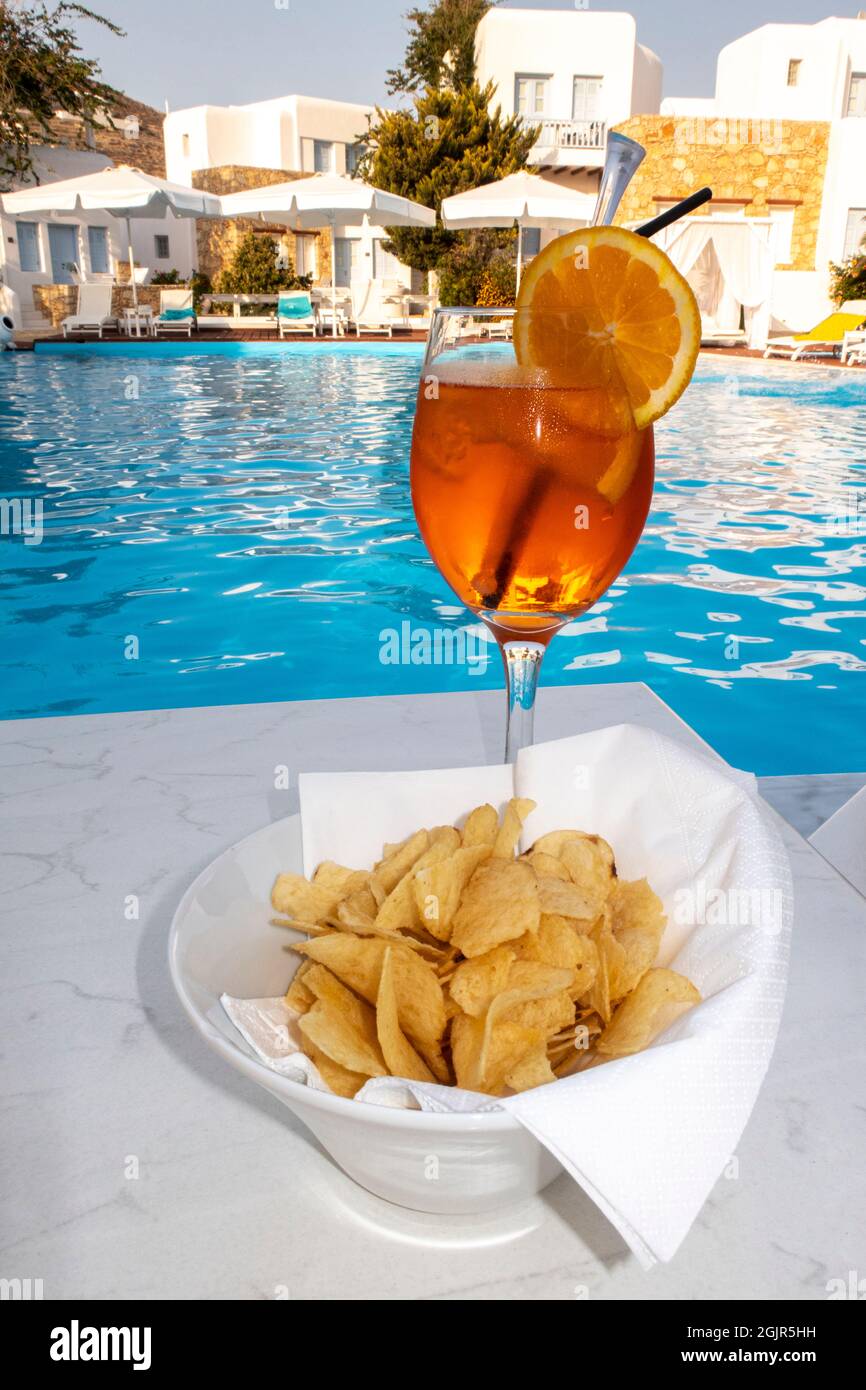 Spritz cocktail drink by the pool along with chips or crisps for cool refreshing snack Stock Photo