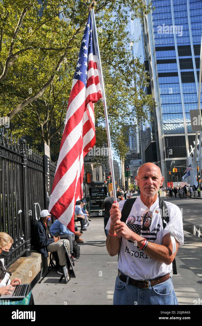 New York City, United States. 11th Sep, 2021. A man holds an American flag on the 20th Anniversary of the events of 9/11, in New York City. Credit: SOPA Images Limited/Alamy Live News Stock Photo