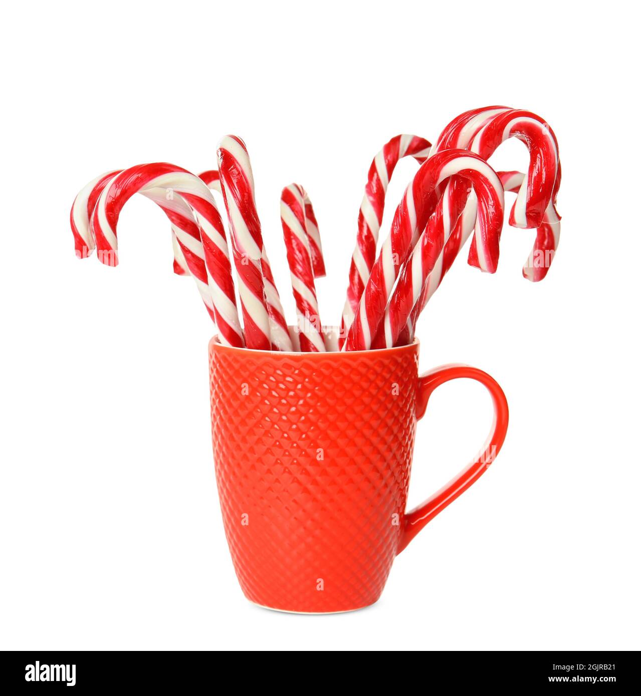Christmas candy canes in cup on white background Stock Photo - Alamy