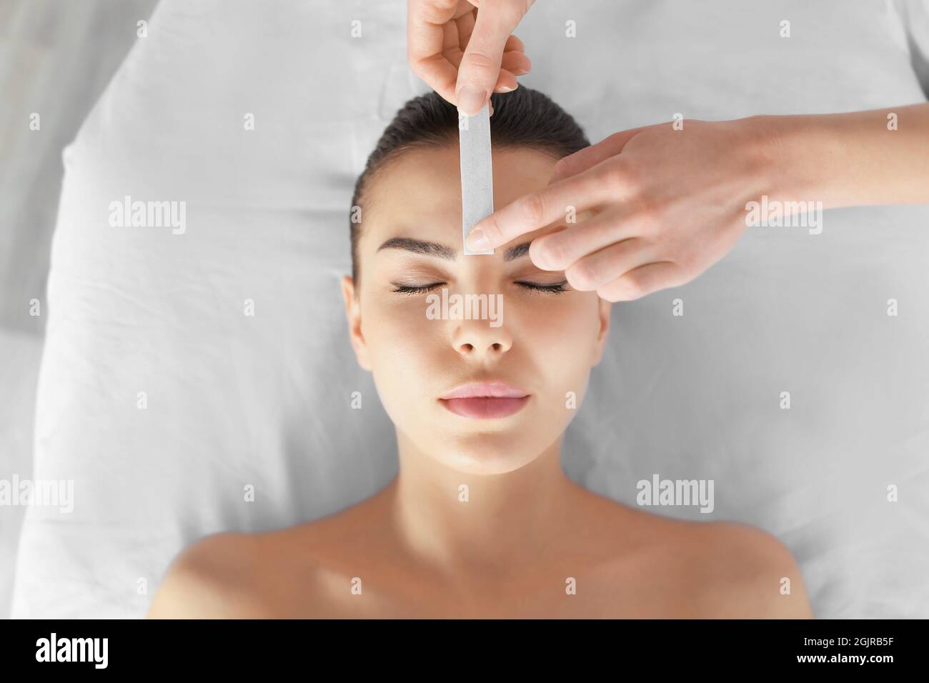 Beautician waxing young woman's eyebrows in spa center Stock Photo Alamy