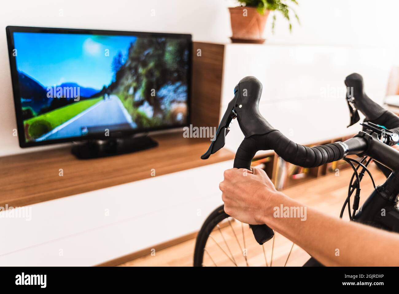 Woman play online bike game in the living room of her home