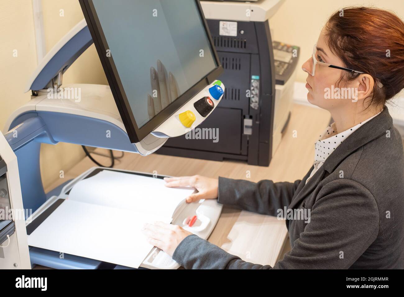 A visually impaired woman uses special reading equipment Stock Photo