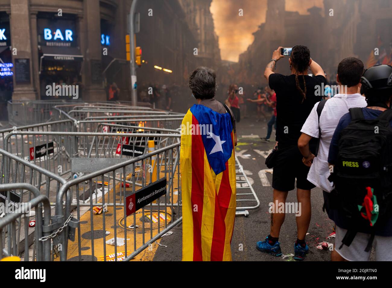 Esp. 11th Sep, 2021. A man covered with a catalan flag is during the riots and clashes hold for the catalan holiday known as 'Diada' in Barcelona, Spain on September 11, 2021. Pro independence and catalan separatists parties such as ANC called for people to take the street in the first major concentration since the covid pandemic began, to remember the fall of Barcelona during the War of the Spanish Succession in 1714. (Photo by Davide Bonaldo/Sipa USA) Credit: Sipa USA/Alamy Live News Stock Photo