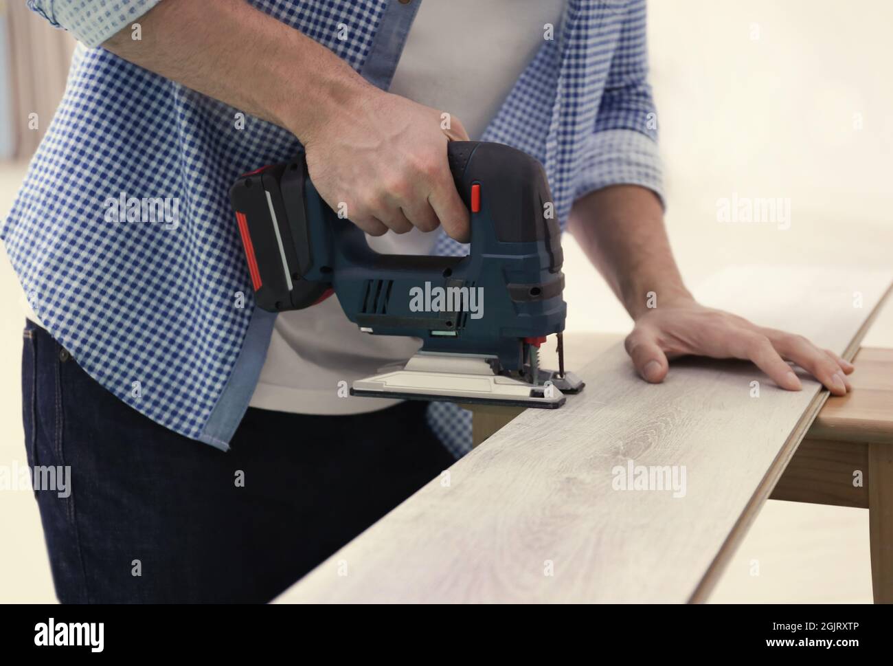 Man cutting laminate board with jigsaw Stock Photo Alamy