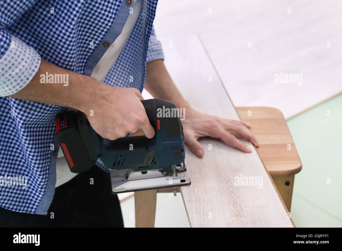 Man cutting laminate board with jigsaw Stock Photo Alamy