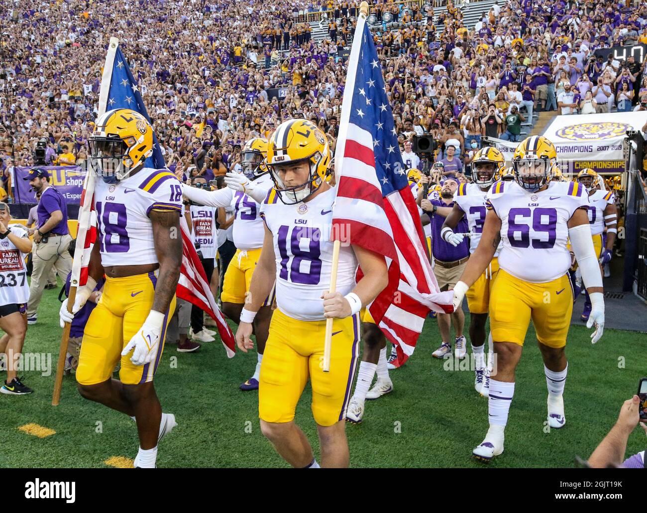 Baton Rouge, LA, USA. 11th Sep, 2021. Teammates Damone Clark (18) and Avery Atkins (18) carry the American Flags in hand on the way to the field on the 20th anniversary of the events of September 11, 2001 before NCAA football game action between the McNeese State University Cowboys and the LSU Tigers at Tiger Stadium in Baton Rouge, LA. Jonathan Mailhes/CSM/Alamy Live News Stock Photo