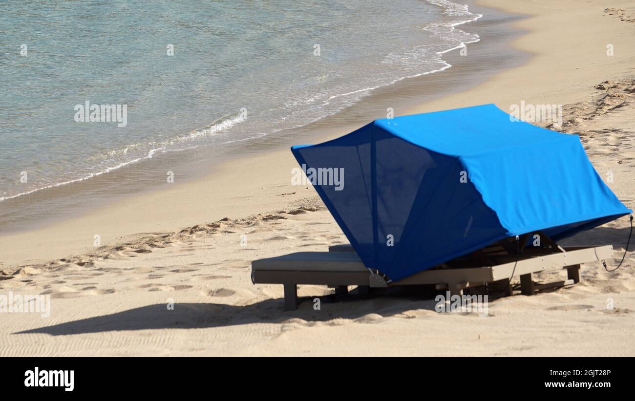 Cabana chair on the sand near the water's edge at a Hawaii resort. Copy space available. Stock Photo