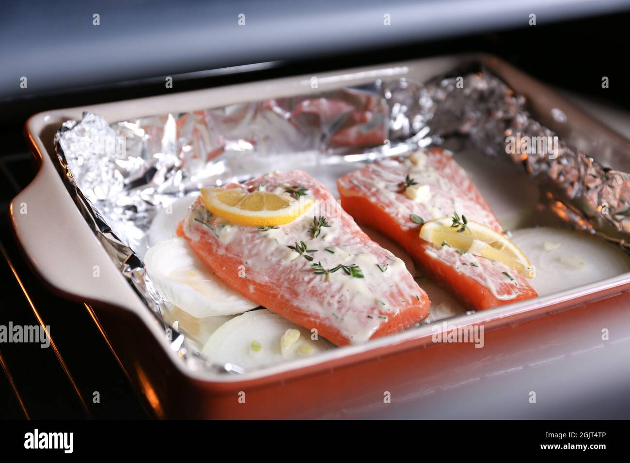 Baking dish with delicious salmon fillet in oven Stock Photo Alamy