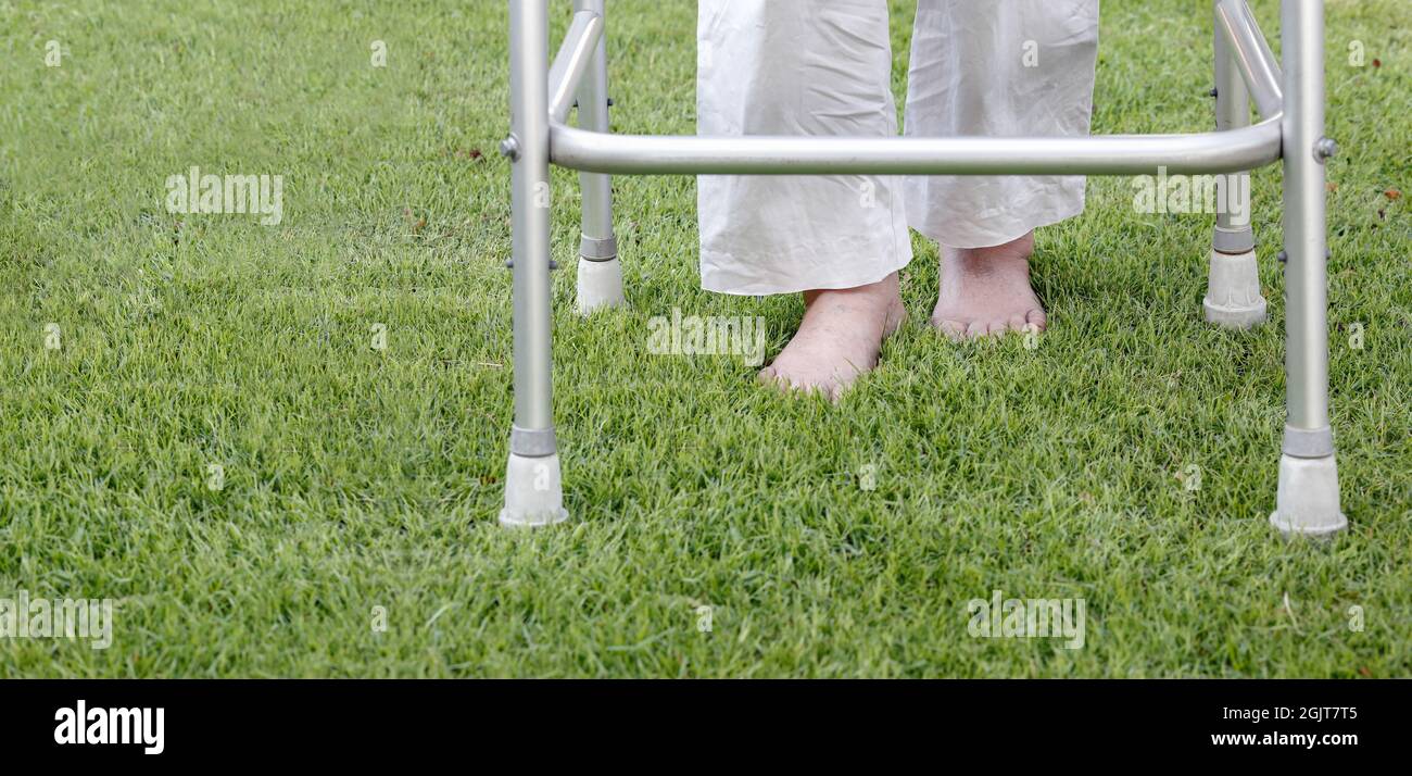Elderly woman walking barefoot therapy on grass in backyard Stock Photo Alamy