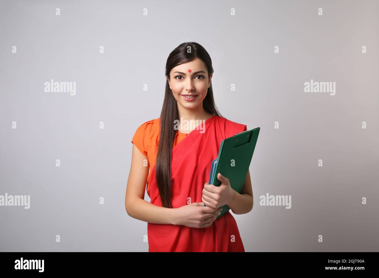 Portrait of Indian female teacher on light grey background Stock Photo