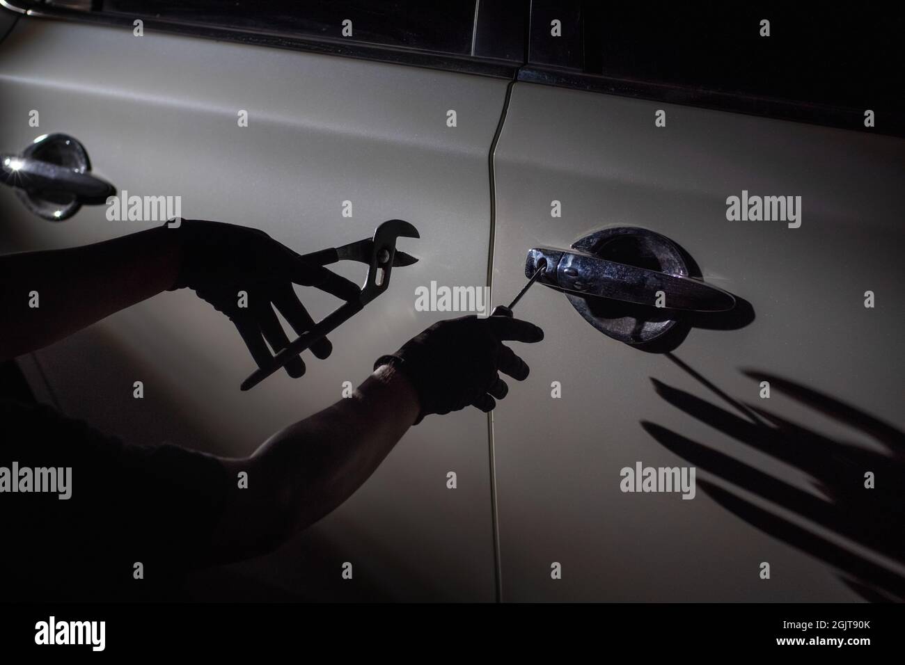 Car thief using a tool to break into a car Stock Photo Alamy