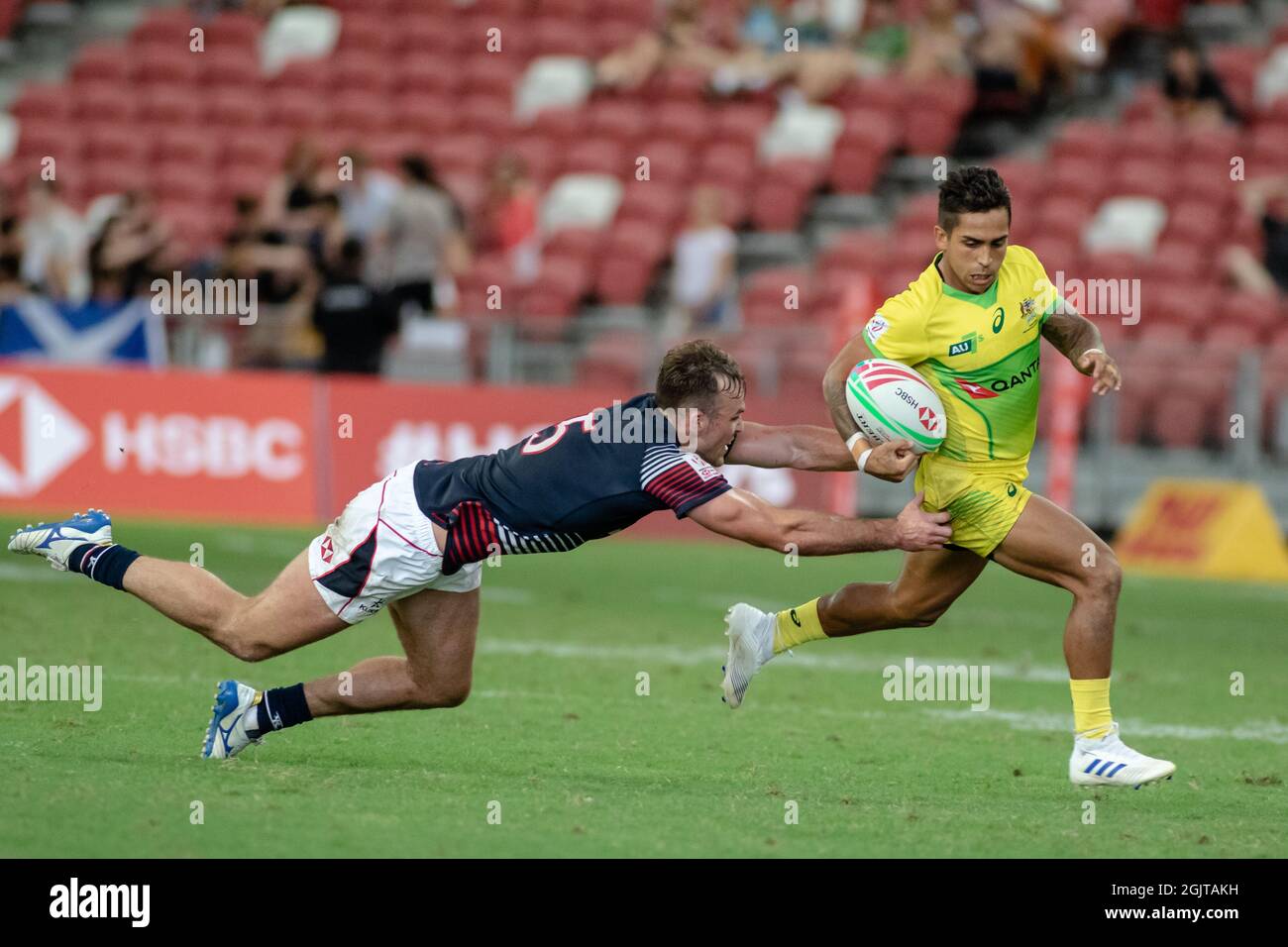 SINGAPORE-APRIL 13:Australia 7s Team (yellow) plays against Hong Kong 7s team (blue/red) during Day 1 of HSBC World Rugby Singapore Sevens on April 13, 2019 at National Stadium in Singapore Stock Photo