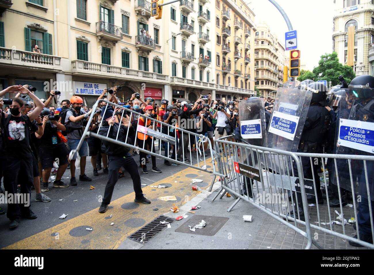 Barcelona, Spain. 11th Sep, 2021. A protester throws a fence at the anti-riot agents of the Catalan Police during the demonstration of the National Day of Catalonia.Pro-independence protesters during the National Day of Catalonia confront the Catalan Police (Mossos d'Escuadra) for throwing cans of paint, smoke, some cans, fire extinguishers, bottles and iron bars at the Spanish Police at their headquarters in Barcelona in protest for the police charges carried out in the illegal referendum of 2017. (Photo by Ramon Costa/SOPA Images/Sipa USA) Credit: Sipa USA/Alamy Live News Stock Photo