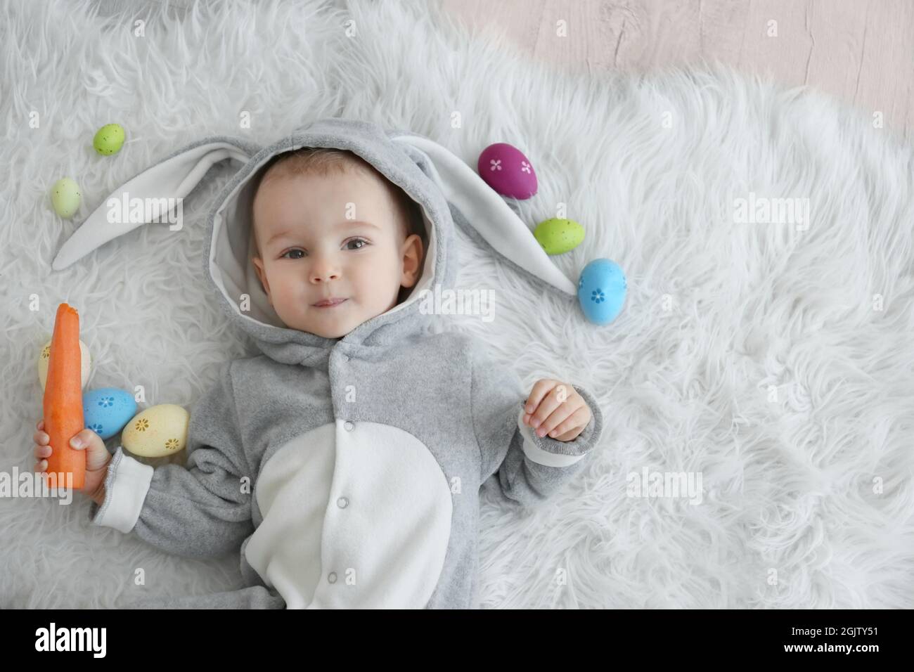 Cute little baby in bunny costume lying on furry rug Stock Photo Alamy
