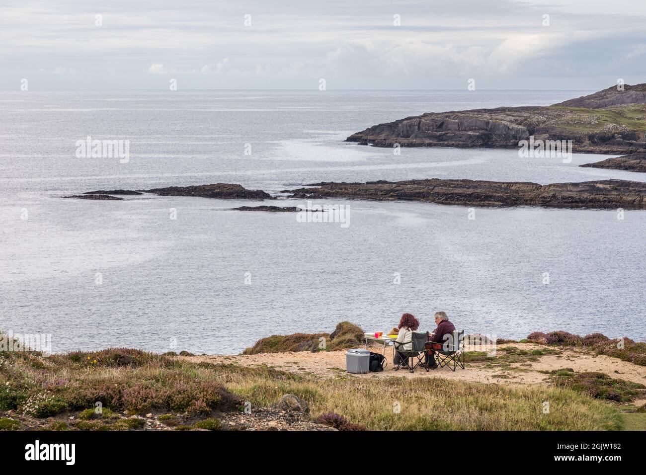 Allihies, Cork, Ireland. 11th September, 2021. Holidaymakers Martine Vandeveegaete and Andre Derval from Lessines in Belgium having an afternoon picnic with a view of Beara's Wild Atlantic Way at Dooneen, Allihies, West Cork, Ireland. - Picture; David Creedon / Alamy Live News Stock Photo