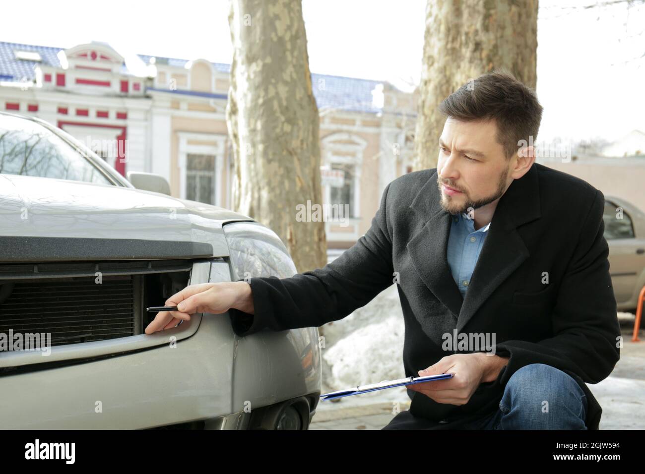 Loss adjuster inspecting car after accident Stock Photo Alamy