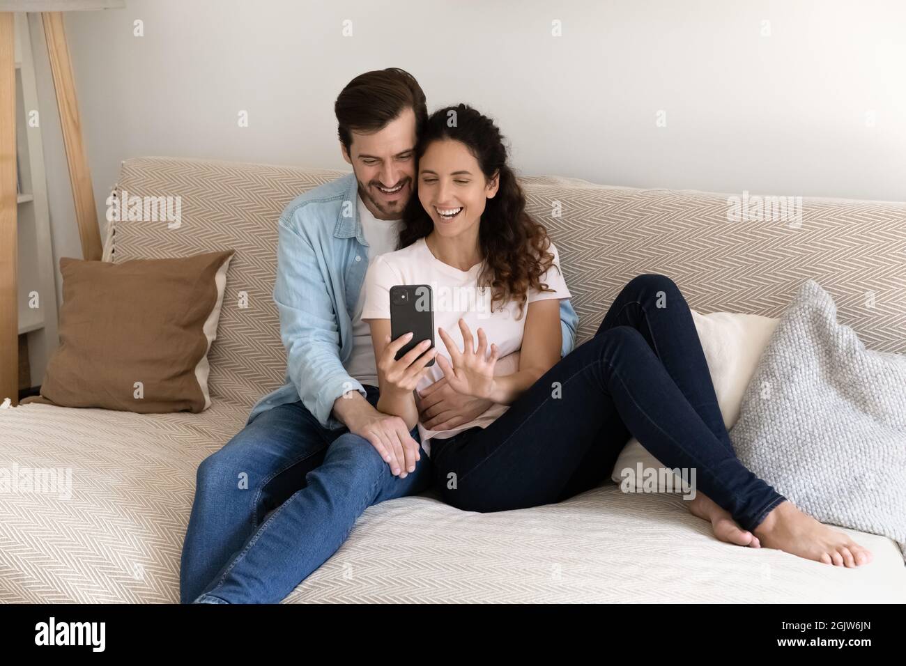 Couple relaxing indoor using smartphone enjoy internet entertainment make videocall Stock Photo