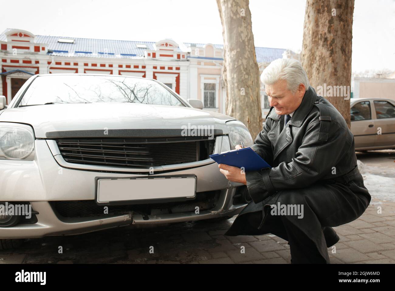 Loss adjuster inspecting car after accident Stock Photo Alamy