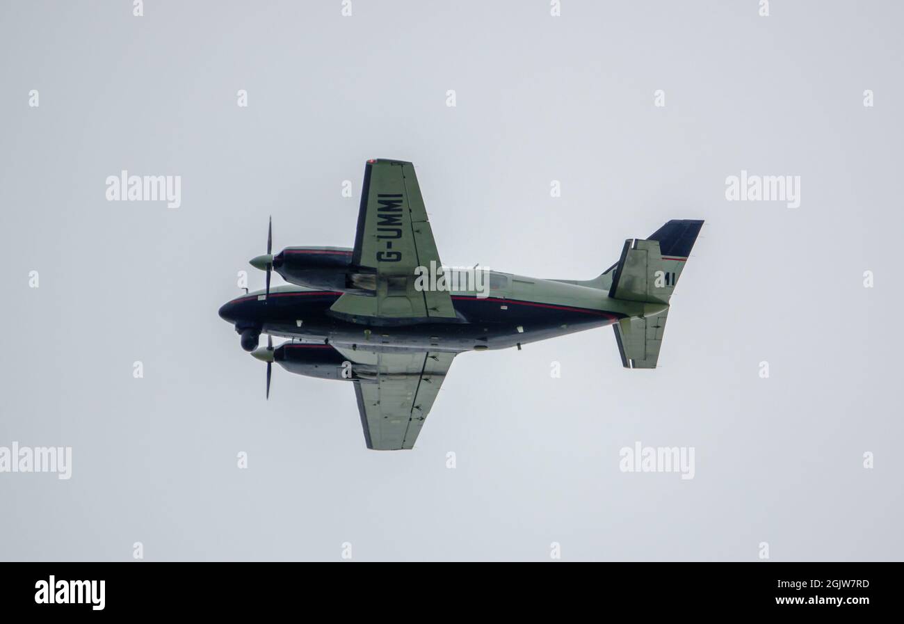 Piper PA-31-310 Navajo C, G-UMMI twin engined cabin class aircraft with surveillance equipment flying over Salisbury Plain military training area UK Stock Photo