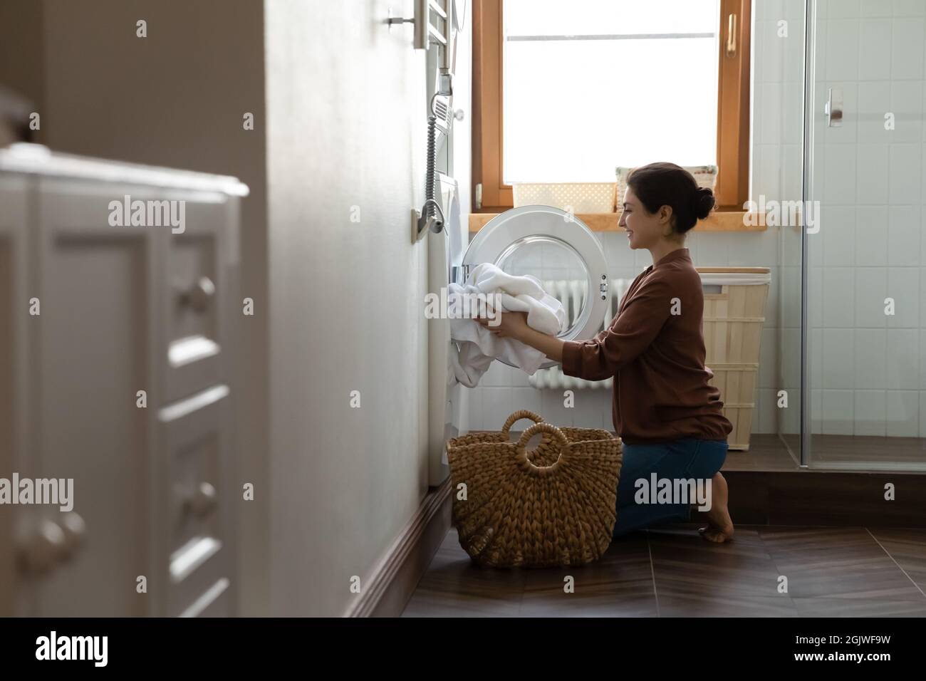 Happy indian woman using modern washing machine for easy laundering Stock Photo